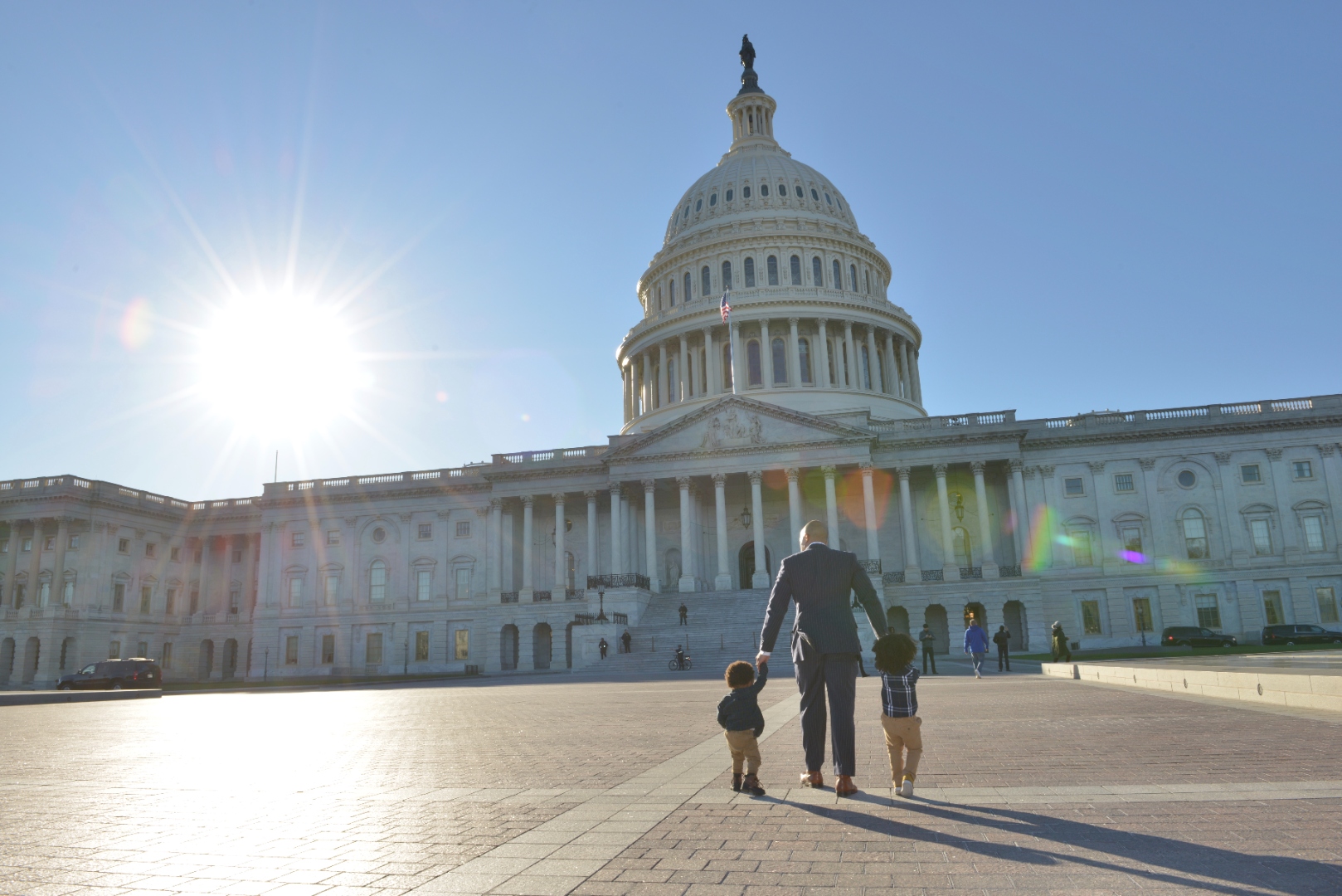 Charles Johnson walking toward the U.S. Capitol holding hands with his two young sons