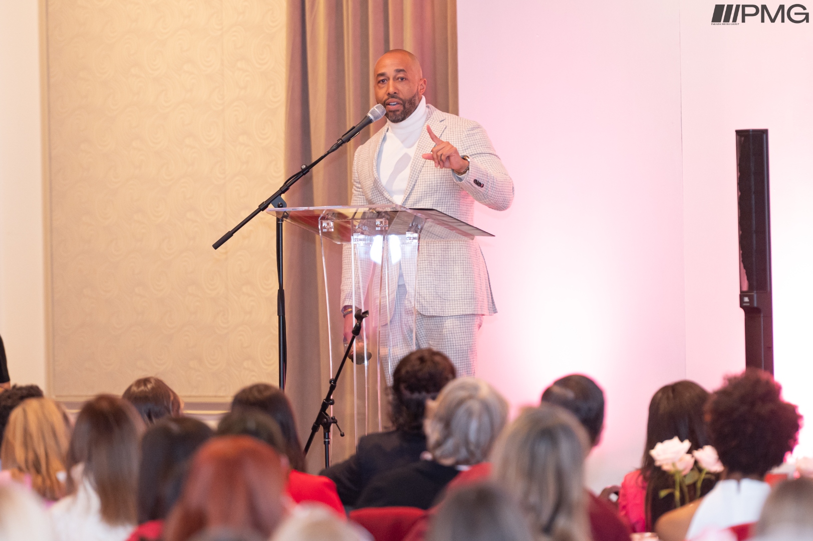 Charles Johnson speaking at indoor gala conference with large audience
